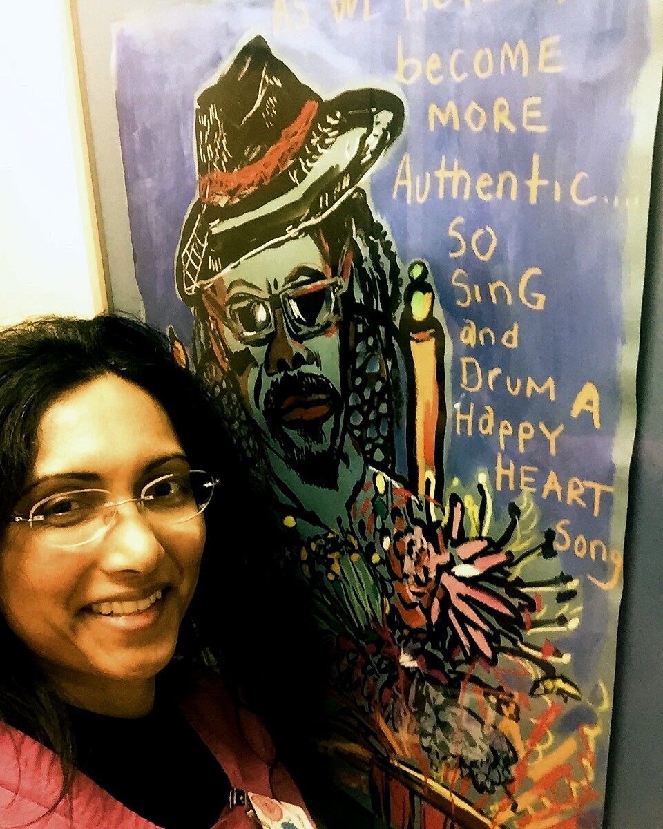 Dr. Umee Davae beside colorful artwork at a clinic